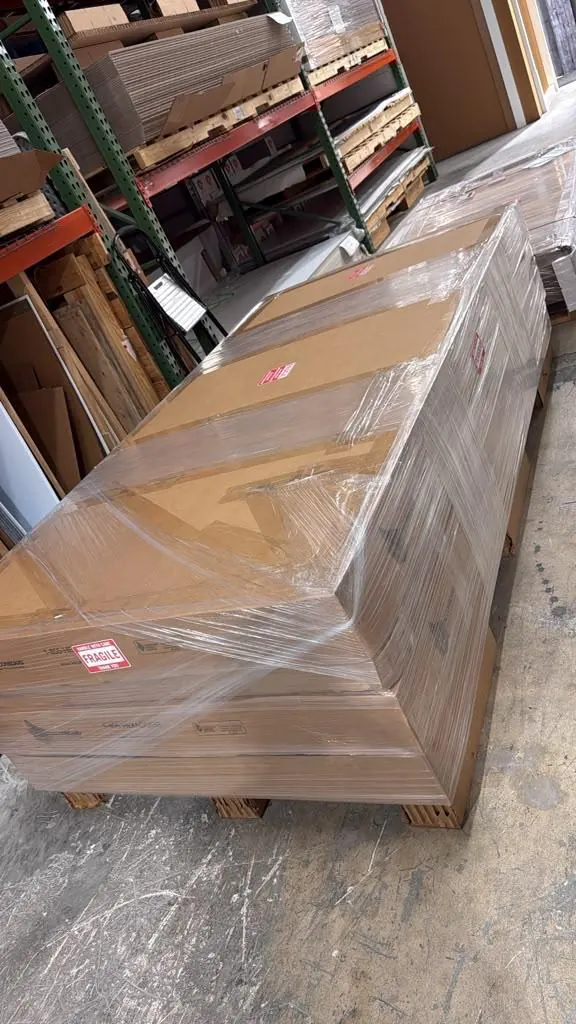 A finished order shrink-wrapped on a 4 by 8 foot pallet with boxes and fragile labels, ready for pickup